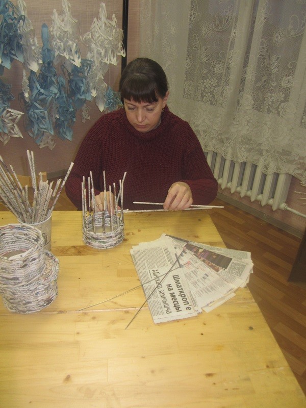 Алла Семеновна показывает, как плетутся  вещи из готовых газетных трубочек