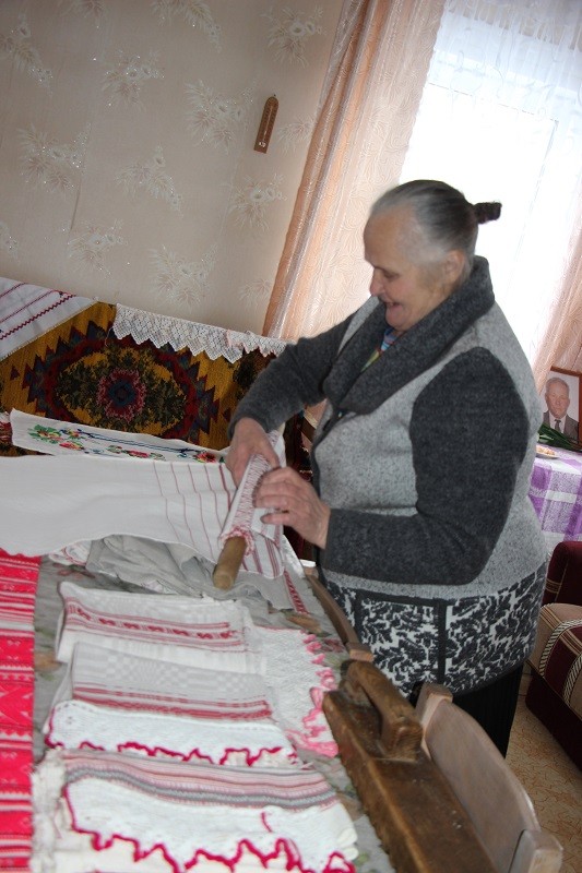 Антаніна Фёдараўна прасуе  саматканыя ручнікі, як гэта рабілі даўней