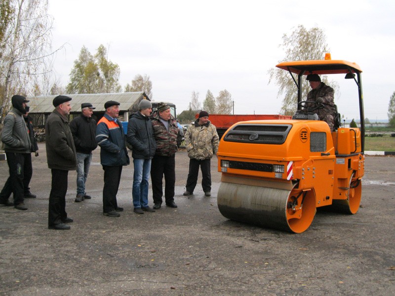 Работники ДРСУ-100 наблюдают за работой нового катка. За рулем машинист катка Сергей Денисеня.