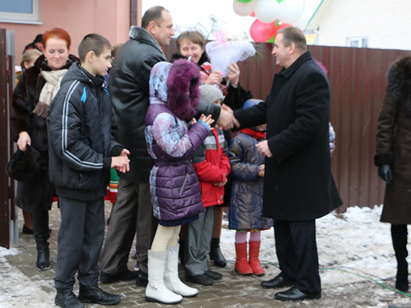 Новоселам вручает подарок глава района Александр Солоневич