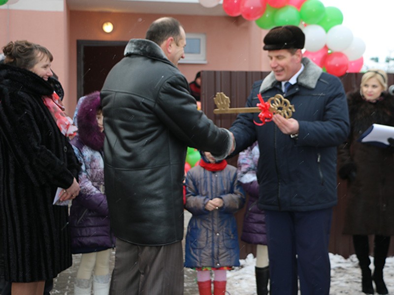 Владимир Рапейко вручает символический ключ главе семьи Леониду Хмелевскому
